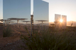 The rising sun peaks through two of Ivanpah's 174,000 mirrors.