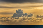 Gorgeous photogrphic image of cumulus clouds over the sea at sunset with strong yellow tones.  Fine Art Print & Canvas Gellery Wrap for Sale.