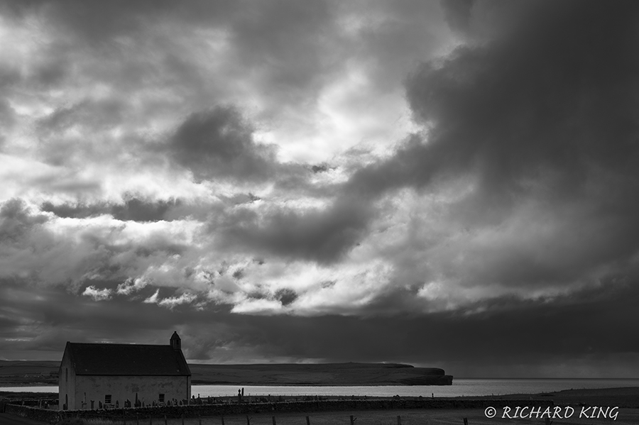 Church, Gravestones and inlet in black and white as the storm approches