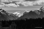 Black and White photograph with billowing Cumulus clouds over the snow capped mountains in the Wrangell Range in Alaska.
