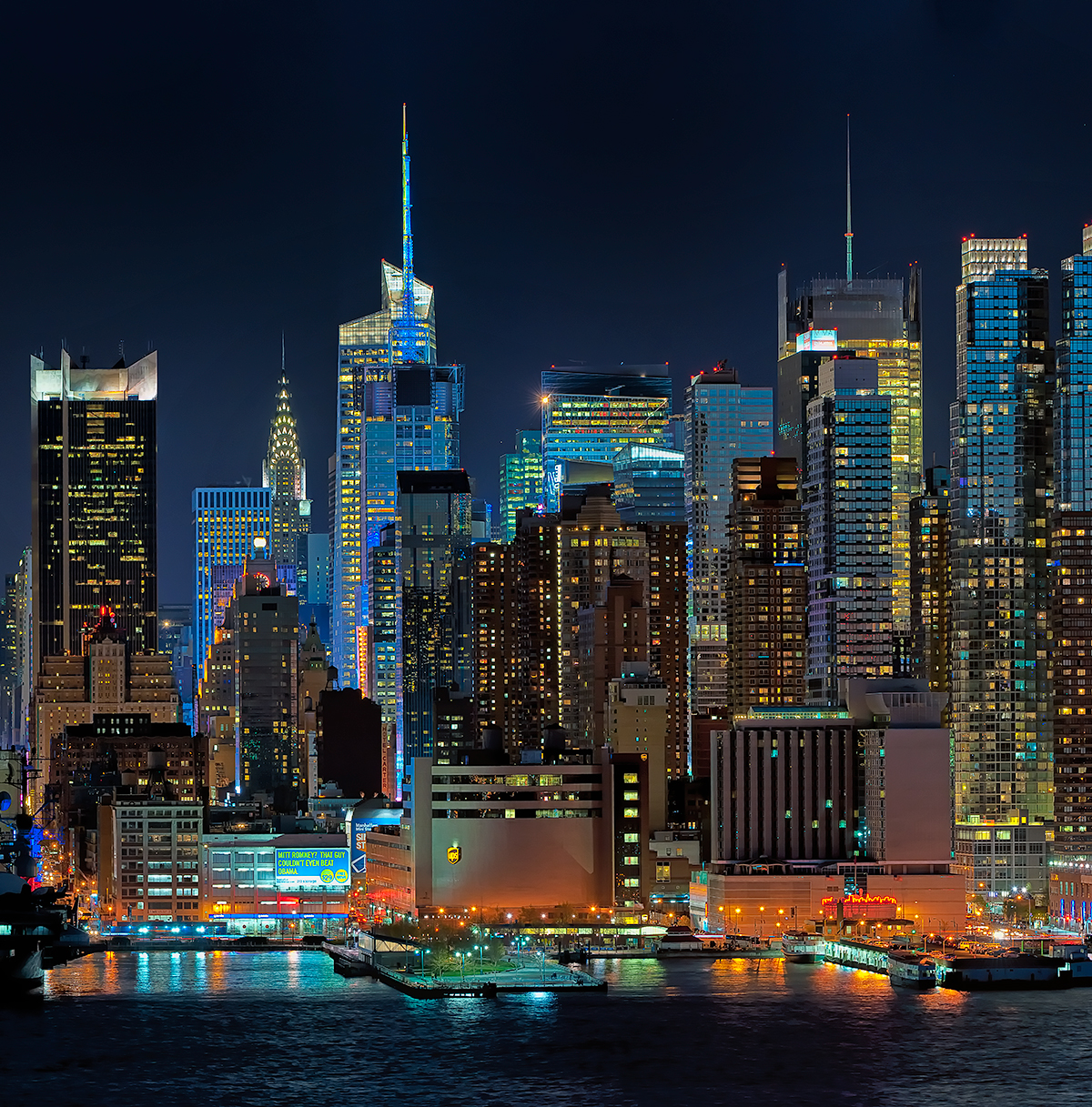 Night panoramic photograph of the Manhattan Skyline with a full moon rising available as a fine art print, canvas gallery wrap or for licensed use