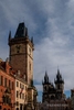 Colour photograph of the Gothic Tower of the Old TOwn Hall in the Old Town Square in Prague with blue sky and clouds.