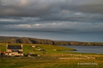 colour photograph of farm houses and croft cottages bathed in the warm sunlight of sunset on the Island of Unst