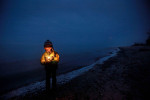 Benjamin Picciolo, 4, holds a candle as he awaits the sunrise on the shores of Lake Michigan to celebrate the winter solstice.