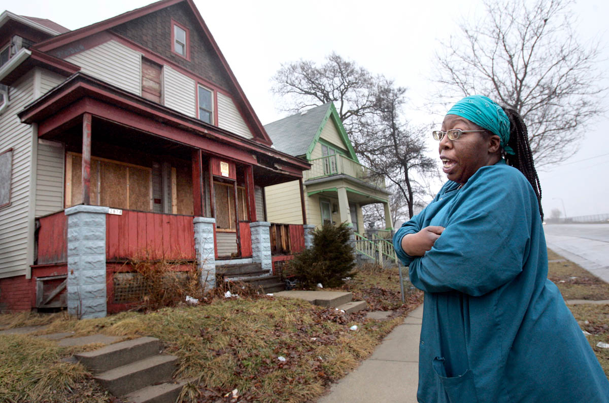 Dawn Powell stands in front of one of her 4 boarding-room houses. No tenants are currently living in that house after one resident died last year due to safety violations that Powell did not fix. Her residences have received numerous health and safety violations but often are not followed through by the city. She currently has 8 tenants that she provides breakfast and dinner to. {quote}As a home owner and a rental person, I would rather deal with people that kind of have mental problems,{quote} says Powell. 