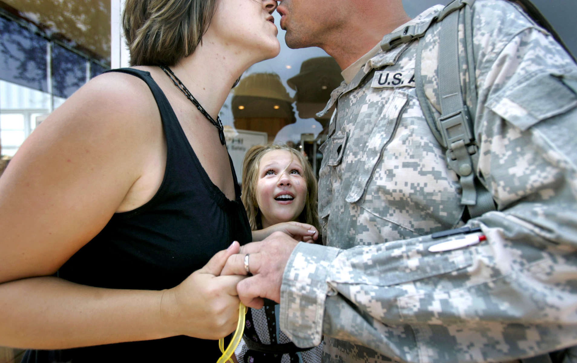 Saharra Lane, 9, of Manawa, watches eagerly as her parents kiss upon the return of her father, Allen Lane, from Iraq. Allen served with the Army National Guard's 1st Battalion, 121st Field Artillery and was deployed for 14-months. 