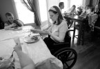 Courtney pokes at her food during Easter dinner. She is seated with her nieces and nephews at the children's table, her back turned to the adults.