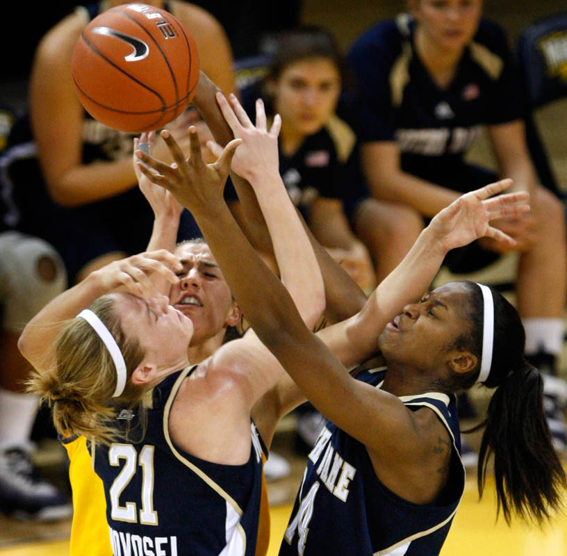 Notre Dame's Natalie Novosel (left) and Devereaux Peters (right) work together to get a loose ball against Marquette's Paige Fiedorowicz during the first half of Wednesday night's game at the Al McGuire Center in Milwaukee, Wis.