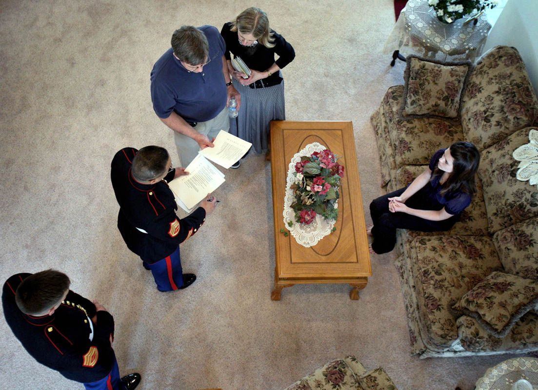 Kristen sits on the couch as Marines give their condolences and discuss arrangements with the family, including his parents Lennie and Susan Nelson, left. The family still does not yet know exactly how Ricky died, and await the return of his body.