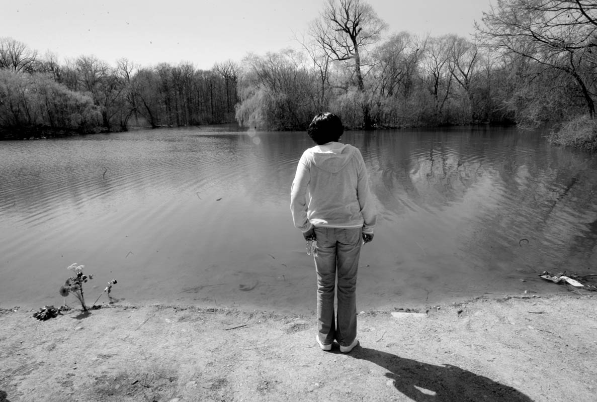 Yolanda Owten stands at the edge of McGovern Park pond, April 17, where the bodies of Quadrevion Henning and Purvis Parker were found after a four-week search. {quote}This is too sad. They are too young,{quote} says Yolanda, who did not know the boys but learned of the story through the news. 