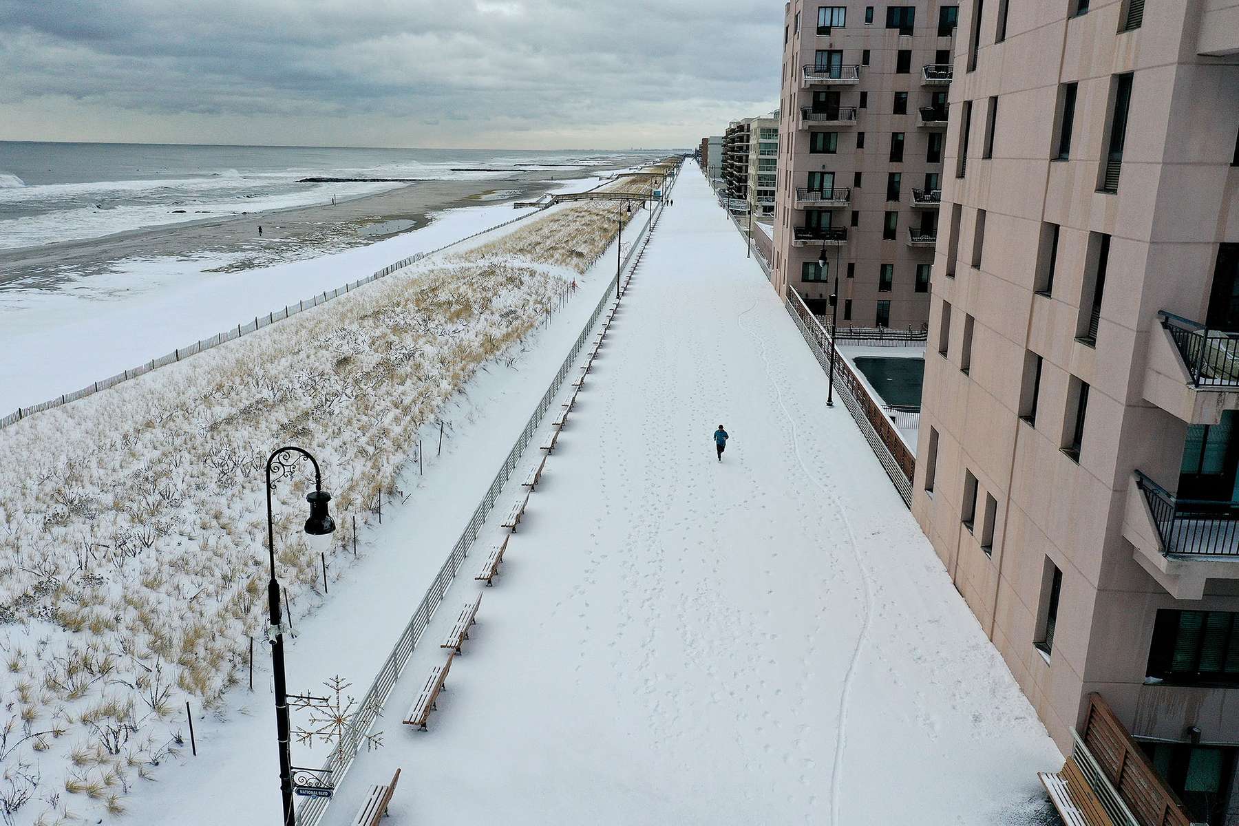 An aerial view of a man running along the boardwalk on December 17, 2020 in Long Beach, New York. Many parts of the Northeast were hit with heavy snowfall in the first big storm of the season.  
