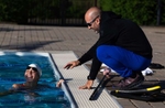 United States Paralympian Anastasia Pagonis talks to her coach Darryn Solotoff during a training session on June 01, 2024 in Syosset, New York.  Pagonis has autoimmune retinopathy which led her sight to decrease at the age of 11, and she lost her vision by the age of 14.  She competed in the swimming competition at the Tokyo 2020 Paralympic Games where she won a gold and bronze medal respectively in the 400m Freestyle S11 and 200-meter Individual Medley S11.  An S11 athlete is the most severe form of visual impairment. S11 swimmers all swim with blacked-out goggles to ensure a level playing field, blocking out all light so it's like swimming with a blindfold.  This is why they typically swim on the lane line and have tappers to inform them when they need to turn or stop.  She will be competing in the 400m Freestyle S11 at the 2024 Paralympic Games this summer in Paris, France. 