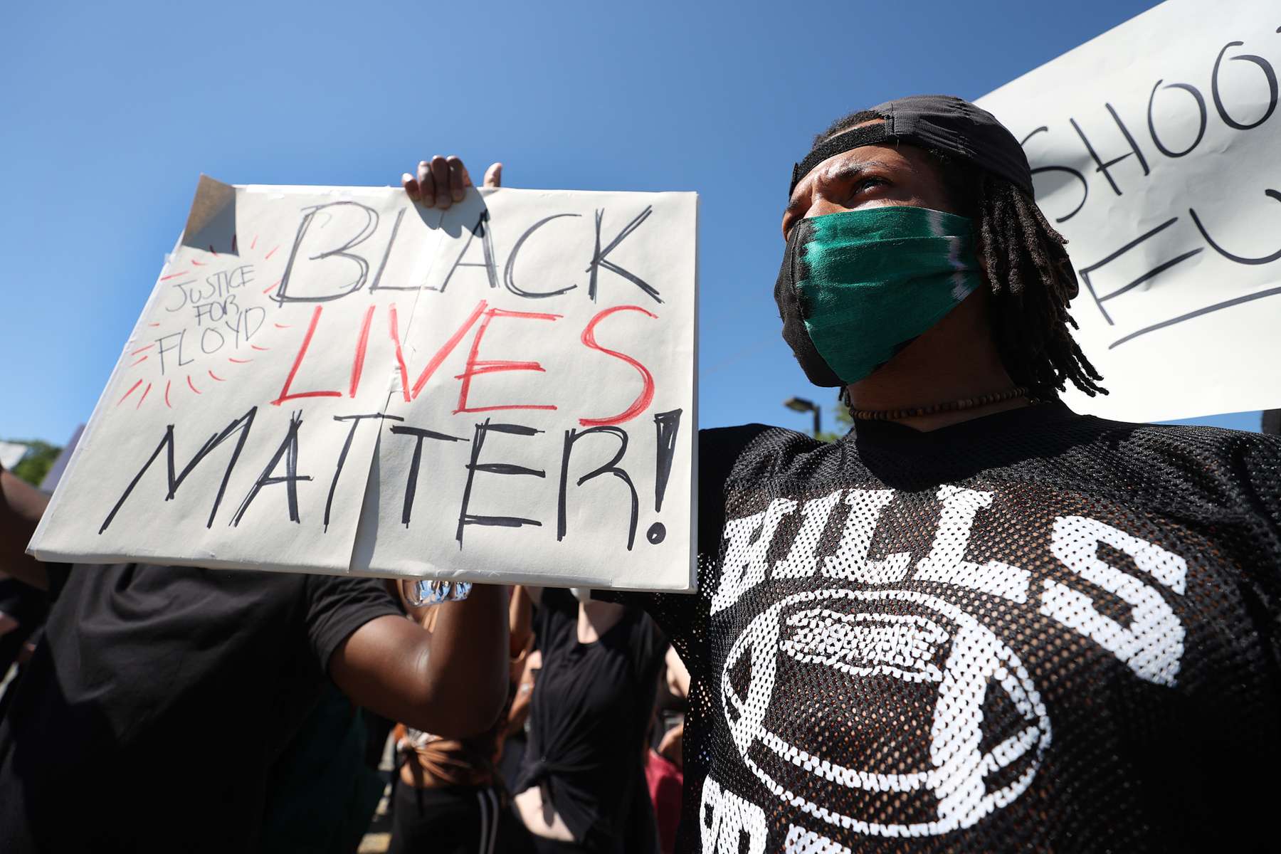 A Protester holds a sign during a gathering at Brentwood State Park to protest the recent death of George Floyd on May 30, 2020 in Brentwood, New York.  Minneapolis Police officer Derek Chauvin was filmed kneeling on George Floyd's neck. Floyd was later pronounced dead at a local hospital. Across the country, protests against Floyd's death have set off days and nights of rage as its the most recent in a series of deaths of black Americans by the police. 