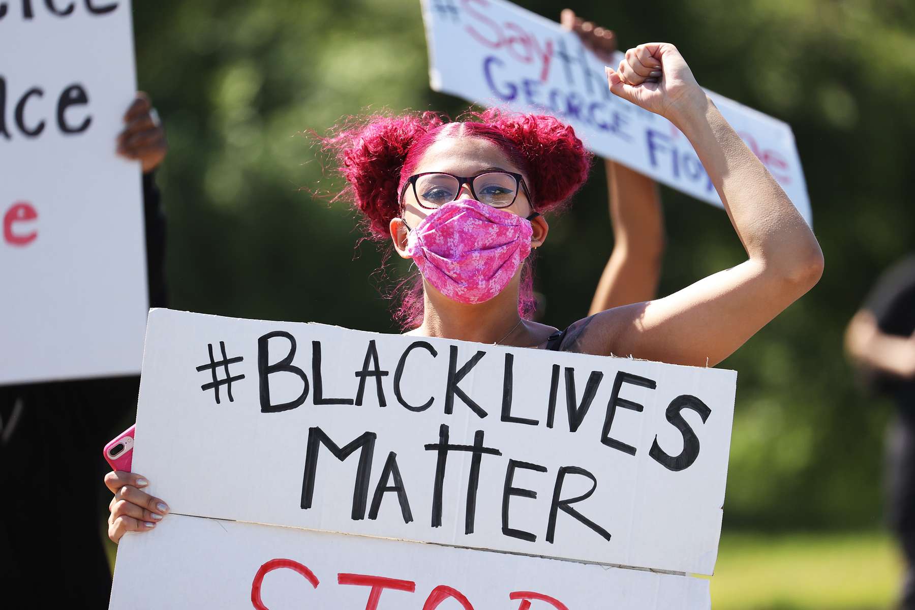 A Protester holds a sign during a gathering at Brentwood State Park to protest the recent death of George Floyd on May 30, 2020 in Brentwood, New York.  Minneapolis Police officer Derek Chauvin was filmed kneeling on George Floyd's neck. Floyd was later pronounced dead at a local hospital. Across the country, protests against Floyd's death have set off days and nights of rage as its the most recent in a series of deaths of black Americans by the police. 