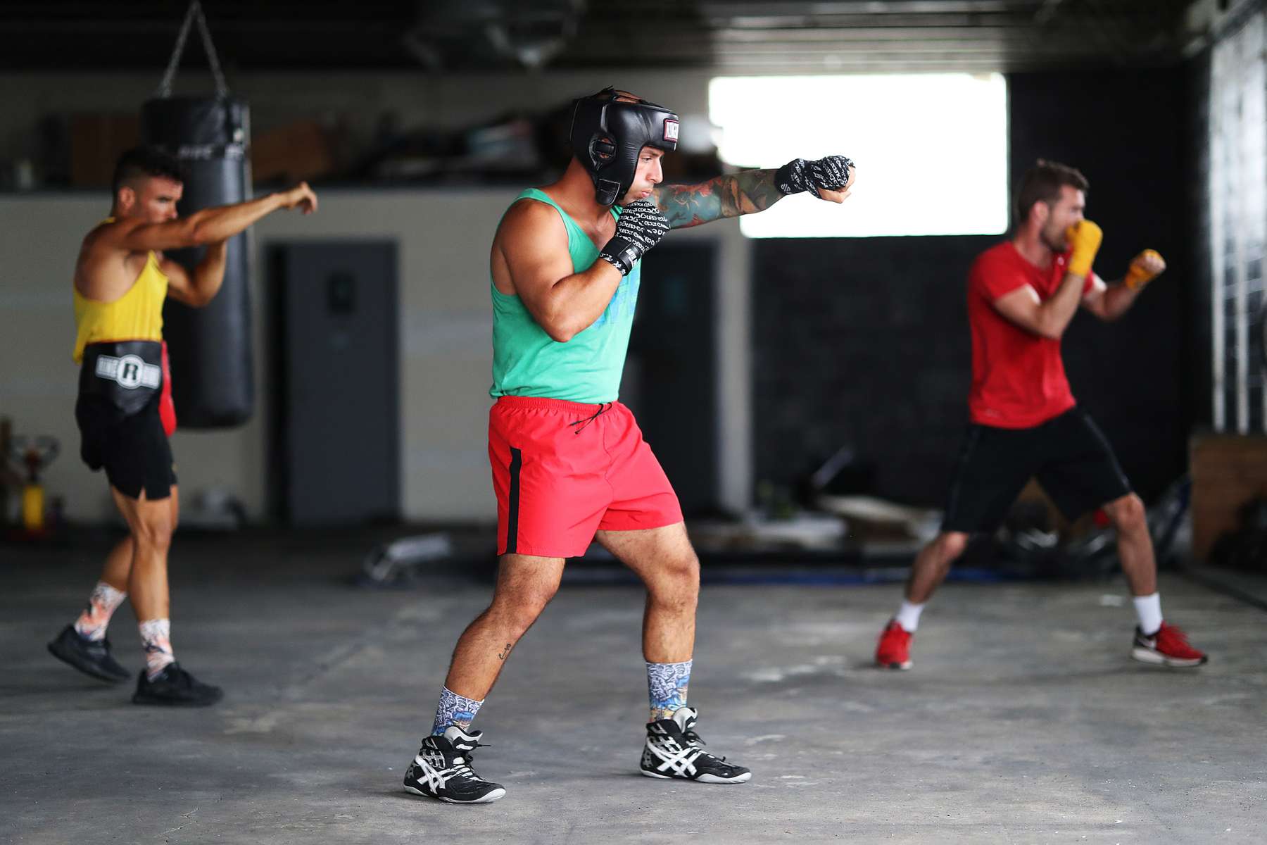 Amateur Kickboxer Sal Carillo (Front), New York Golden Gloves boxer Dennis Guerrero (right), and three time New York Golden Glove boxer Anthony Lopez, shadowbox during training session in a warehouse that was once Jetty gym on July 30, 2020 in Oceanside, New York. Guerrero, who is a co owner of Jetty has tried to hold many types of outdoor and open air workouts while the gym remains closed due to the coronavirus pandemic.  Since all gyms in New York had been closed since March 13, they have been trying to keep up financially to sustain the gym. Guerrero and his partner Michael Levitz have decided to closed their doors for good next week.  They will be moving their workouts online and at select locations.  Governor Andrew Cuomo announced that gyms will not be permitted to reopen during phase 4 until New York's Health Department determines if air filtering systems are circulating the coronavirus. More than 4,540,000 people in the United States alone have been infected with the coronavirus and at least 154,000 have died.  
