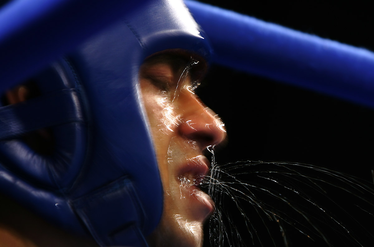 Marian Simion of Romania gets a water break in his corner between rounds in his bout against Ramadan Yasser of Egypt during the men's boxing 51 kg preliminary bout on August 21, 2004 during the Athens 2004 Summer Olympic Games at Peristeri Olympic Boxing Hall in Athens, Greece. 