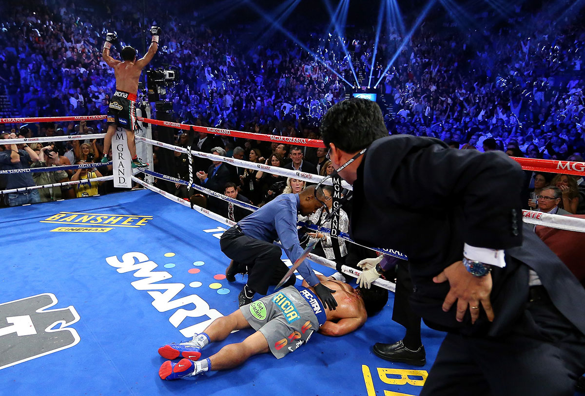 Manny Pacquiao lays face down on the mat after being knocked out in the sixth round as Juan Manuel Marquez celebrates during their welterweight bout at the MGM Grand Garden Arena on December 8, 2012 in Las Vegas, Nevada.  