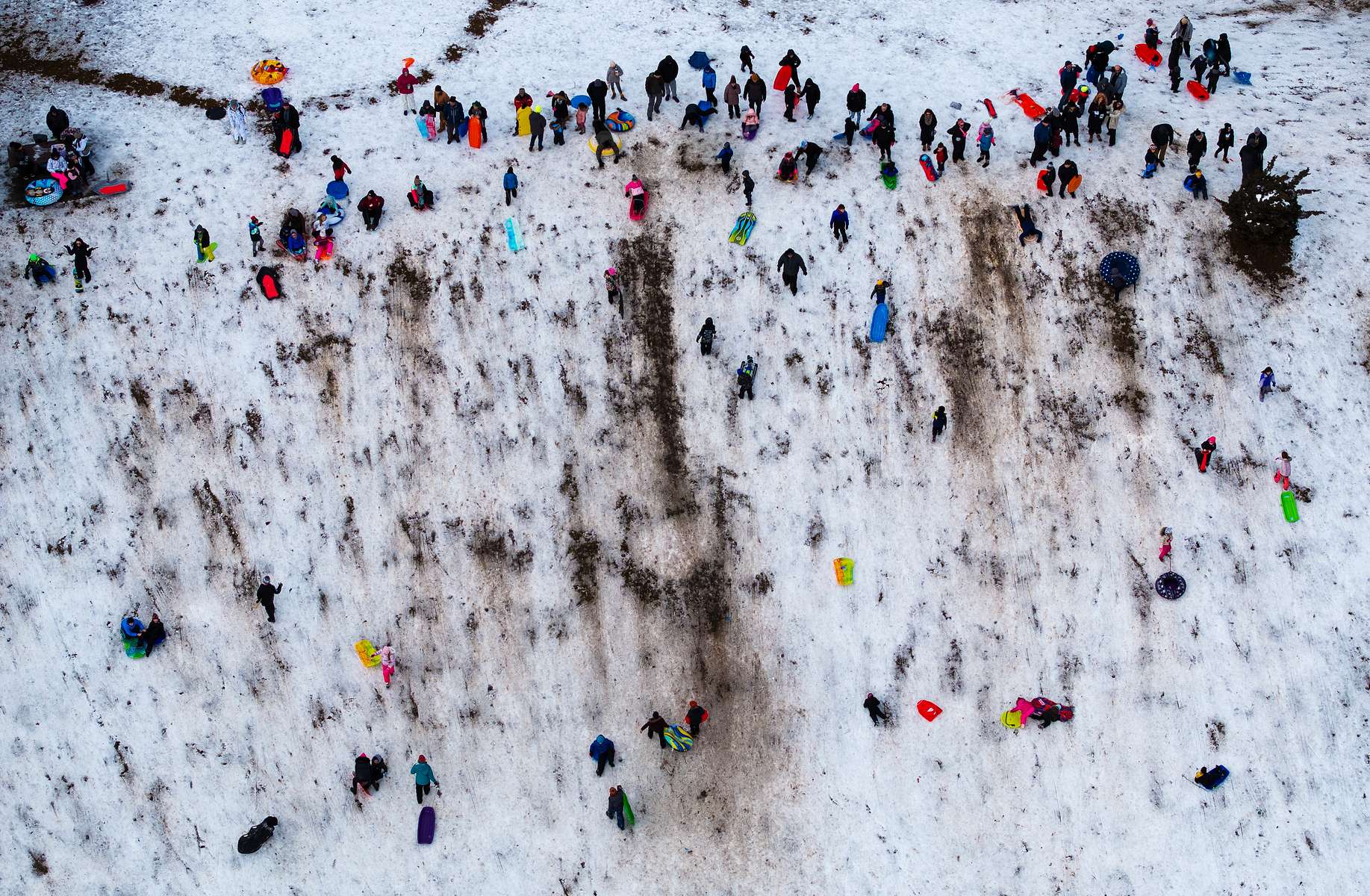 An aerial view of  people sledding after a large winter storm passed through the area on February 13, 2024 in Seaford, New York.  Much of the Northeast is experiencing snow, wind and freezing temperatures with many businesses closed and schools in New York City going remote for the day. 