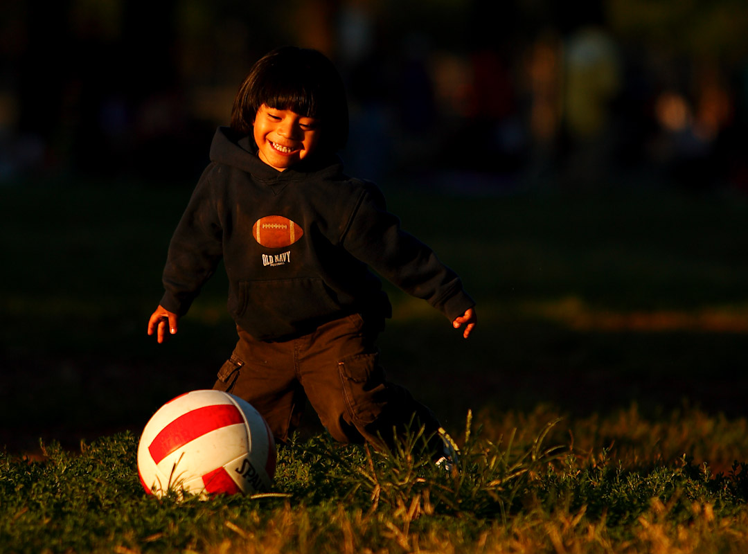 A young child plays a pickup game of soccer as his adult relatives participate in the Fedeiguayas Soccer League on September 2, 2007 at Flushing Meadows Park in Queens, New York. 