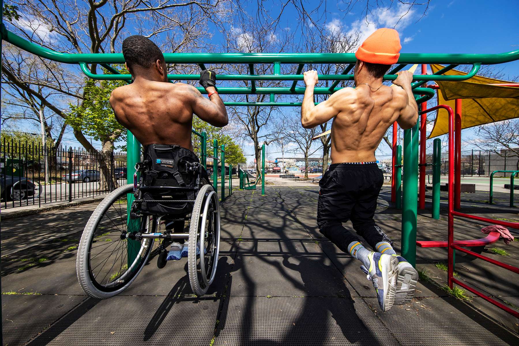 Team USA Para Powerlifter Garrison Redd does pull ups  in his wheelchair with fitness trainer Dennis Guerrero on the Monkey Bars in Robert E. Venable Park on April 13, 2021 in Brooklyn, New York. 