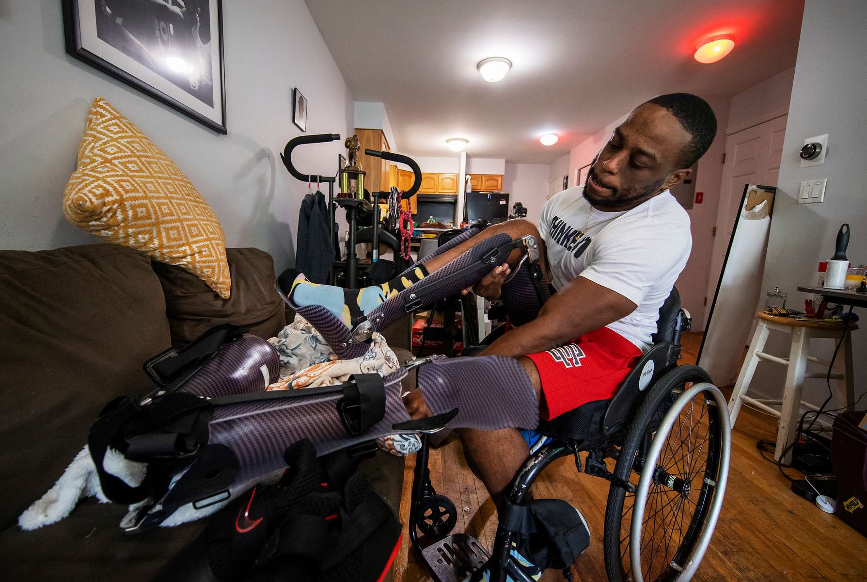 Team USA Para Powerlifter Garrison Redd installs Kafo Leg braces that secure his legs, knees, and ankles.   Once the braces are installed to his legs he is able to walk using his upper body strength,  and assistance of a walker on October 25, 2021 in Brooklyn, New York.  
