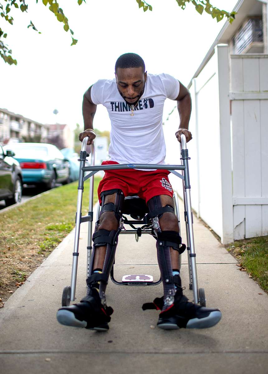 Team USA Para Powerlifter Garrison Redd is upright wearing Kafo Leg braces, as he walks using his upper body strength, and the assistance of a walker at his home on October 25, 2021 in Brooklyn, New York. 