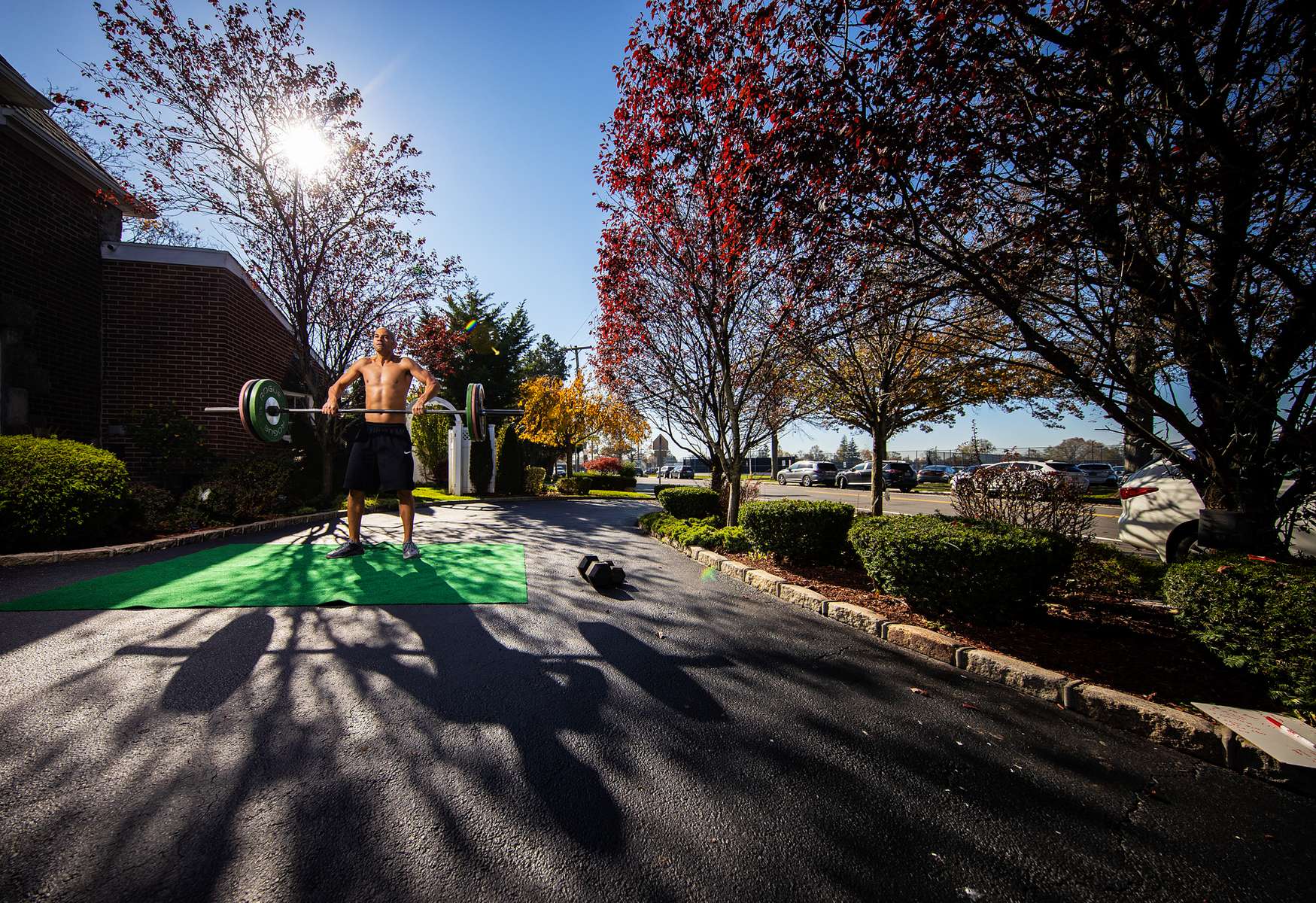  Loneil Jenkins exercises in front of his home with his virtual Fitness Trainer Dennis Guerrero on November 9th, 2020 in Oceanside, New York.  In March of 2014, Dennis Guerrero and his business partner opened a gym on Long Island. The pair shared a passion for fitness, a dream of creating a local community of like-minded people and a willingness to take a risk. Over the next six years, hundreds of members experienced and embraced a unique environment that fostered a palpable energy, helping athletes of all ages and abilities reach their potential.  The gym became a place to share achievements, work through losses and overcome illness. But like so many other businesses, it seemingly had no way of overcoming the financial impact and ongoing uncertainty of a global pandemic. With the arrival of Covid-19, the gym shut its doors back in March, with no idea when it would reopen. The owners, though, were far from done. They lent out every piece of equipment they owned to the gym’s members, continued to pay their staff and worked to set up outdoor classes in hopes of keeping their membership active and healthy. As the shutdown stretched on, it became clear that the physical gym was closed for good.  They have since reinvented themselves and are now called Life Outside the Box.  Their business model has changed drastically, and all their workouts have gone virtual.  The workouts are conducted by a small group of fitness trainers led by Guerrero.  The members pay a monthly fee and can take live Zoom fitness classes.  They are coached by the virtual trainers in real time.  More and more people have reconstructed their garages, spare rooms, backyards, and basements into home gyms since the COVID-19 pandemic hit the United States. 