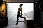 LONG BEACH, NEW YORK - NOVEMBER 21:  Nicole Guerrero exercises in her garage with her virtual Fitness Trainer and Husband Dennis Guerrero on November 21st, 2020 in Long Beach, New York. In March of 2014, Dennis Guerrero and his business partner opened a gym on Long Island. The pair shared a passion for fitness, a dream of creating a local community of like-minded people and a willingness to take a risk. Over the next six years, hundreds of members experienced and embraced a unique environment that fostered a palpable energy, helping athletes of all ages and abilities reach their potential.  The gym became a place to share achievements, work through losses and overcome illness. But like so many other businesses, it seemingly had no way of overcoming the financial impact and ongoing uncertainty of a global pandemic. With the arrival of Covid-19, the gym shut its doors back in March, with no idea when it would reopen. The owners, though, were far from done. They lent out every piece of equipment they owned to the gym’s members, continued to pay their staff and worked to set up outdoor classes in hopes of keeping their membership active and healthy. As the shutdown stretched on, it became clear that the physical gym was closed for good.  They have since reinvented themselves and are now called Life Outside the Box.  Their business model has changed drastically, and all their workouts have gone virtual.  The workouts are conducted by a small group of fitness trainers led by Guerrero.  The members pay a monthly fee and can take live Zoom fitness classes.  They are coached by the virtual trainers in real time.  More and more people have reconstructed their garages, spare rooms, backyards, and basements into home gyms since the COVID-19 pandemic hit the United States.  (Photo by Al Bello/Getty Images)