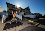 Dennis Guerrero, who is Co-owner, and Head Trainer of Life Outside the Box fitness trains outside his home on November 8th, 2020 in Long Beach, New York.   In March of 2014, Dennis Guerrero and his business partner opened a gym on Long Island. The pair shared a passion for fitness, a dream of creating a local community of like-minded people and a willingness to take a risk. Over the next six years, hundreds of members experienced and embraced a unique environment that fostered a palpable energy, helping athletes of all ages and abilities reach their potential.  The gym became a place to share achievements, work through losses and overcome illness. But like so many other businesses, it seemingly had no way of overcoming the financial impact and ongoing uncertainty of a global pandemic. With the arrival of Covid-19, the gym shut its doors back in March, with no idea when it would reopen. The owners, though, were far from done. They lent out every piece of equipment they owned to the gym’s members, continued to pay their staff and worked to set up outdoor classes in hopes of keeping their membership active and healthy. As the shutdown stretched on, it became clear that the physical gym was closed for good.  They have since reinvented themselves and are now called Life Outside the Box.  Their business model has changed drastically, and all their workouts have gone virtual.  The workouts are conducted by a small group of fitness trainers led by Guerrero.  The members pay a monthly fee and can take live Zoom fitness classes.  They are coached by the virtual trainers in real time.  More and more people have reconstructed their garages, spare rooms, backyards, and basements into home gyms since the COVID-19 pandemic hit the United States.   