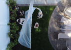 An aerial view of Olivia and James Grant hug their Grandparents Mary Grace and Domenik Sileo through a plastic drop cloth hung up on a homemade clothes line during Memorial Day Weekend on May 24, 2020 in Wantagh, New York.  It is the first time they have had physical contact of any kind since the coronavirus COVID-19 pandemic lockdown started in late February.  
