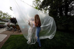 Julia Sileo hugs her Grandmother Mary Grace Sileo through a plastic drop cloth hung up on a homemade clothes line during Memorial Day Weekend on May 24, 2020 in Wantagh, New York.  It is the first time they have had physical contact of any kind since the coronavirus COVID-19 pandemic lockdown started in late February.  