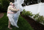 Julia Sileo hugs her Grandfather Domenik Sileo through a plastic drop cloth hung up on a homemade clothes line during Memorial Day Weekend on May 24, 2020 in Wantagh, New York.  It is the first time they have had physical contact of any kind since the coronavirus COVID-19 pandemic lockdown started in late February.  
