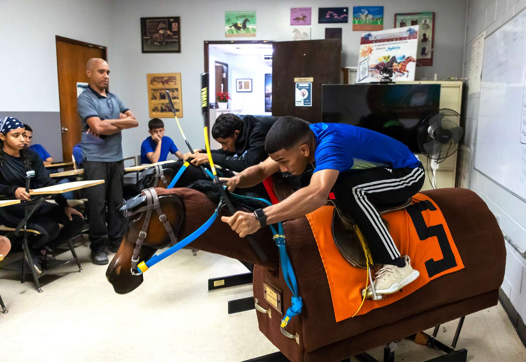 Student Jockeys use a Racehorse Simulator during class taught by Instructor Willie Lozano at the Vocational Equestrian Agustín Mercado Reverón School located in the Hipódromo Camarero on November 15, 2022 in Canovanas, Puerto Rico. The Vocational Equestrian Agustín Mercado Reverón School has produced some of the best jockeys in the world but also prepares students for a wide range of equestrian jobs on a tuition-free basis.  