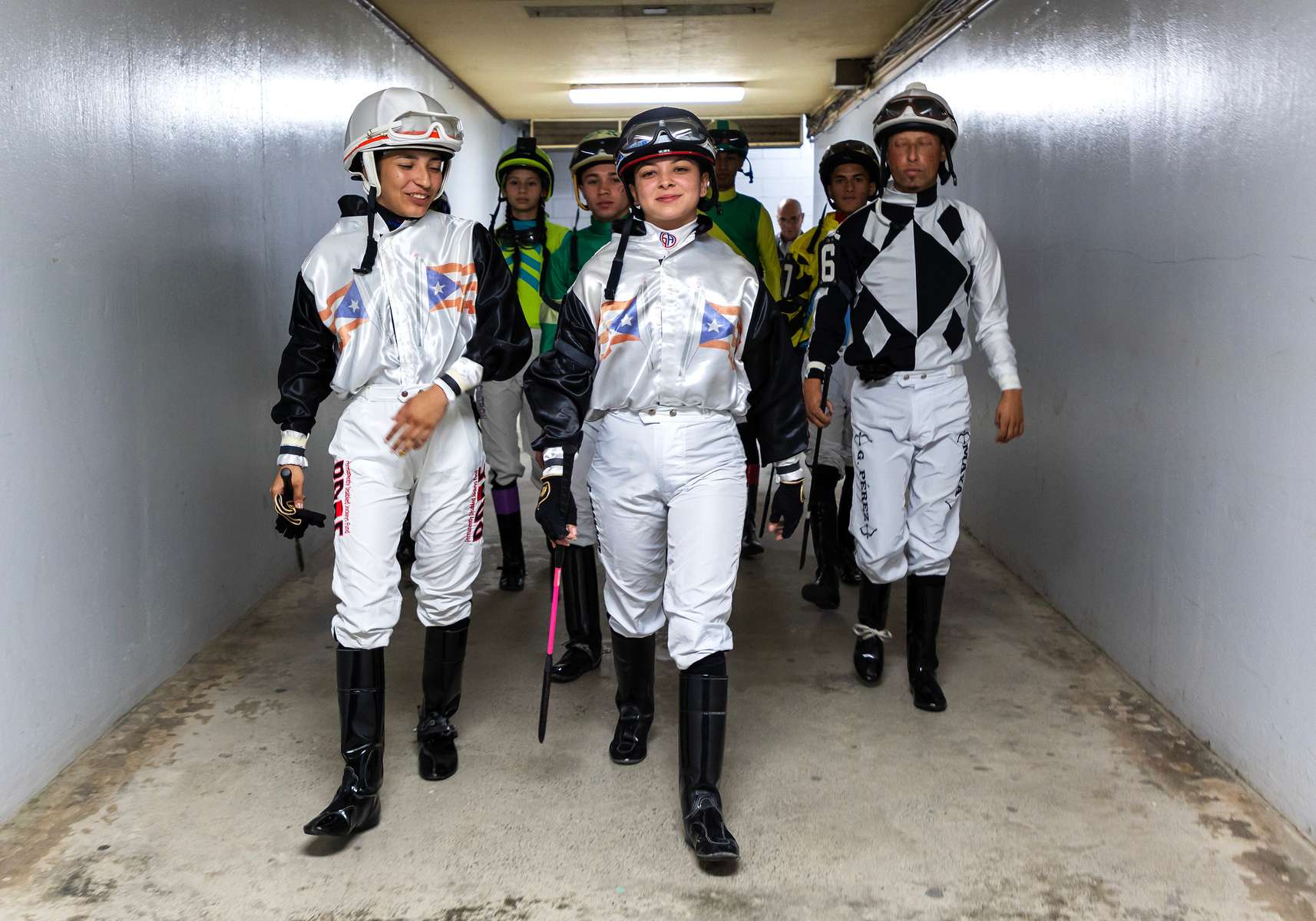 Student Jockeys make the walk from the locker room to the racetrack before their race at the Vocational Equestrian Agustín Mercado Reverón School located in the Hipódromo Camarero on November 18, 2022 in Canovanas, Puerto Rico. The Vocational Equestrian Agustín Mercado Reverón School has produced some of the best jockeys in the world but also prepares students for a wide range of equestrian jobs on a tuition-free basis. 