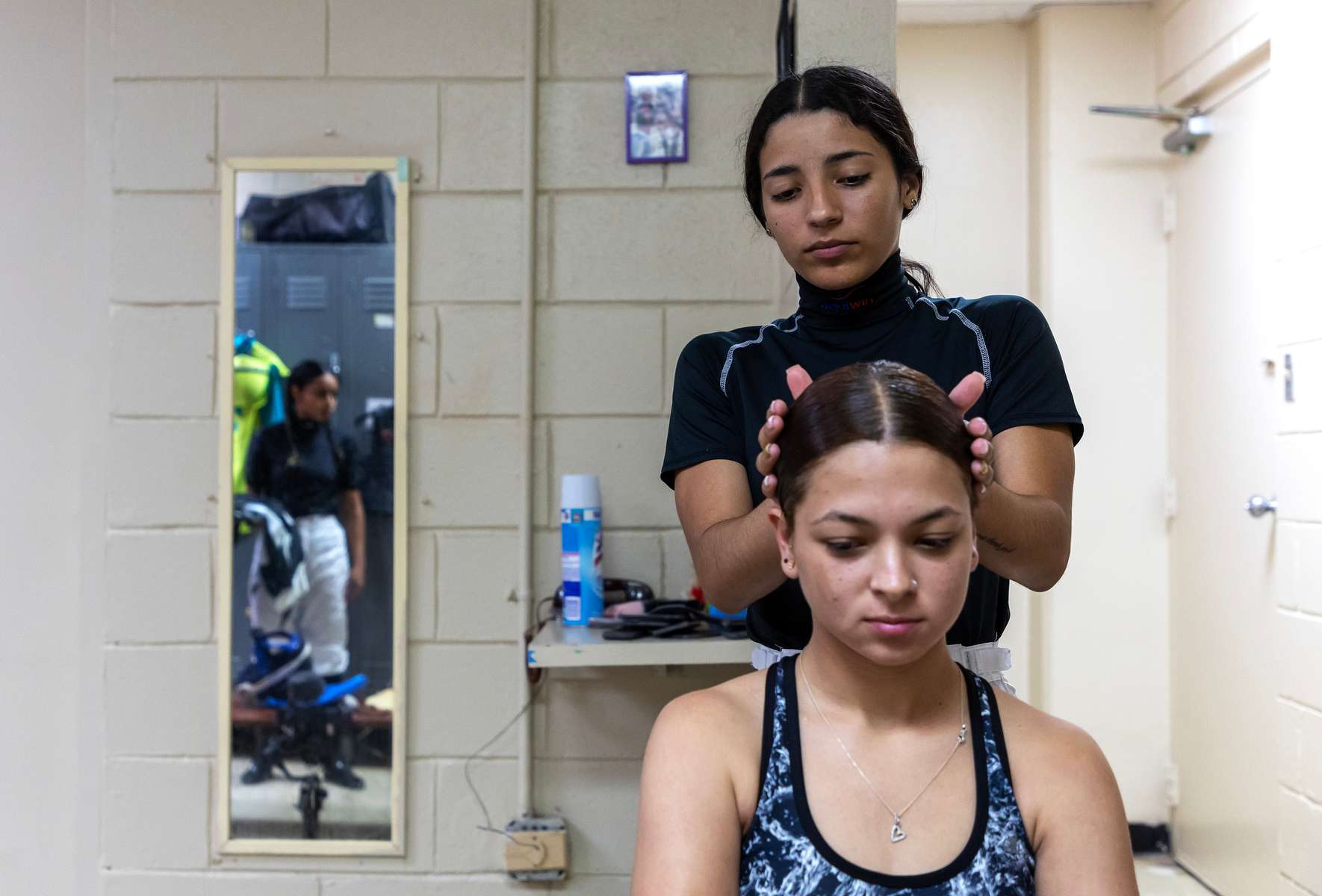 Student Jockey Valeria Melendez  braids the hair of fellow student jockey Elbaliz Rodriguez at the Vocational Equestrian Agustín Mercado Reverón School located in the Hipódromo Camarero on November 18, 2022 in Canovanas, Puerto Rico. The Vocational Equestrian Agustín Mercado Reverón School has produced some of the best jockeys in the world but also prepares students for a wide range of equestrian jobs on a tuition-free basis.  