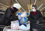 A shopper and cashier both wear masks, gloves and the cashier also has on a plastic visor at the checkout station Pat's Farms grocery store on March 31, 2020 in Merrick, New York.   The World Health Organization declared coronavirus (COVID-19) a global pandemic on March 11th.  
