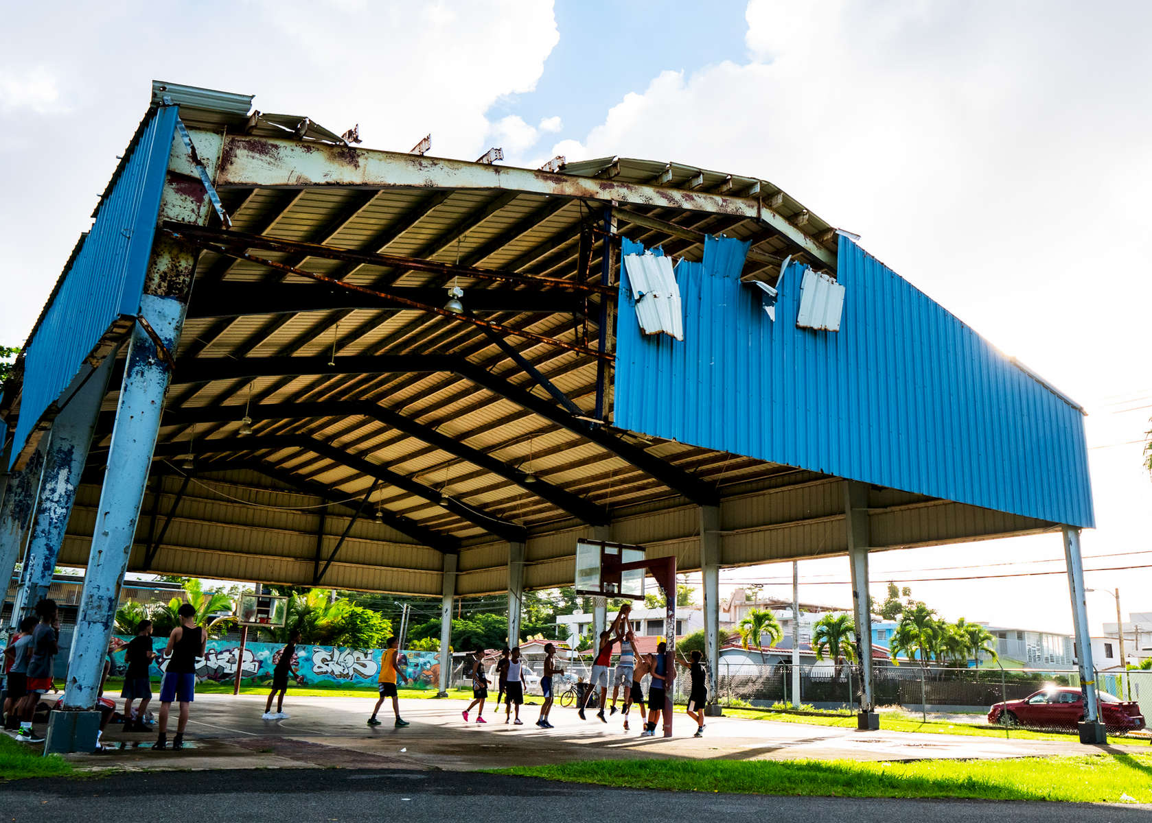OCEAN PARK, PUERTO RICO - NOVEMBER 12:  People play basketball under a heavily damaged open air roof structure caused by Hurricane Maria at Parque Balboa on November 12, 2018 in Ocean Park, Puerto Rico. The effort continues in Puerto Rico to remain and rebuild more than one year after the Hurricane Maria hit and devastated the island on September 20, 2017. The official number of deaths from the disaster is 2,975.