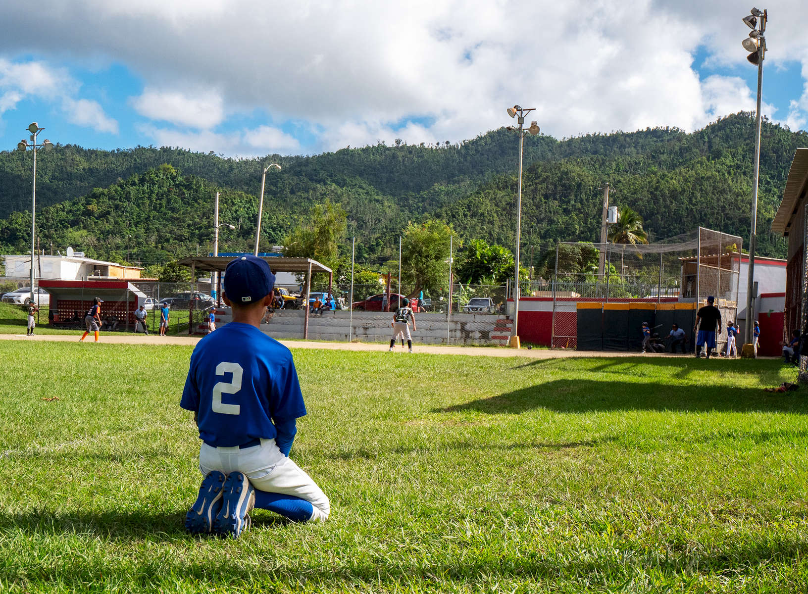 CAYEY, PUERTO RICO - NOVEMBER 10: A boy looks on during a Little League baseball game on November 10, 2018 in Cayey, Puerto Rico. The effort continues in Puerto Rico to remain and rebuild more than one year after the Hurricane Maria hit and devastated the island on September 20, 2017. The official number of deaths from the disaster is 2,975. 