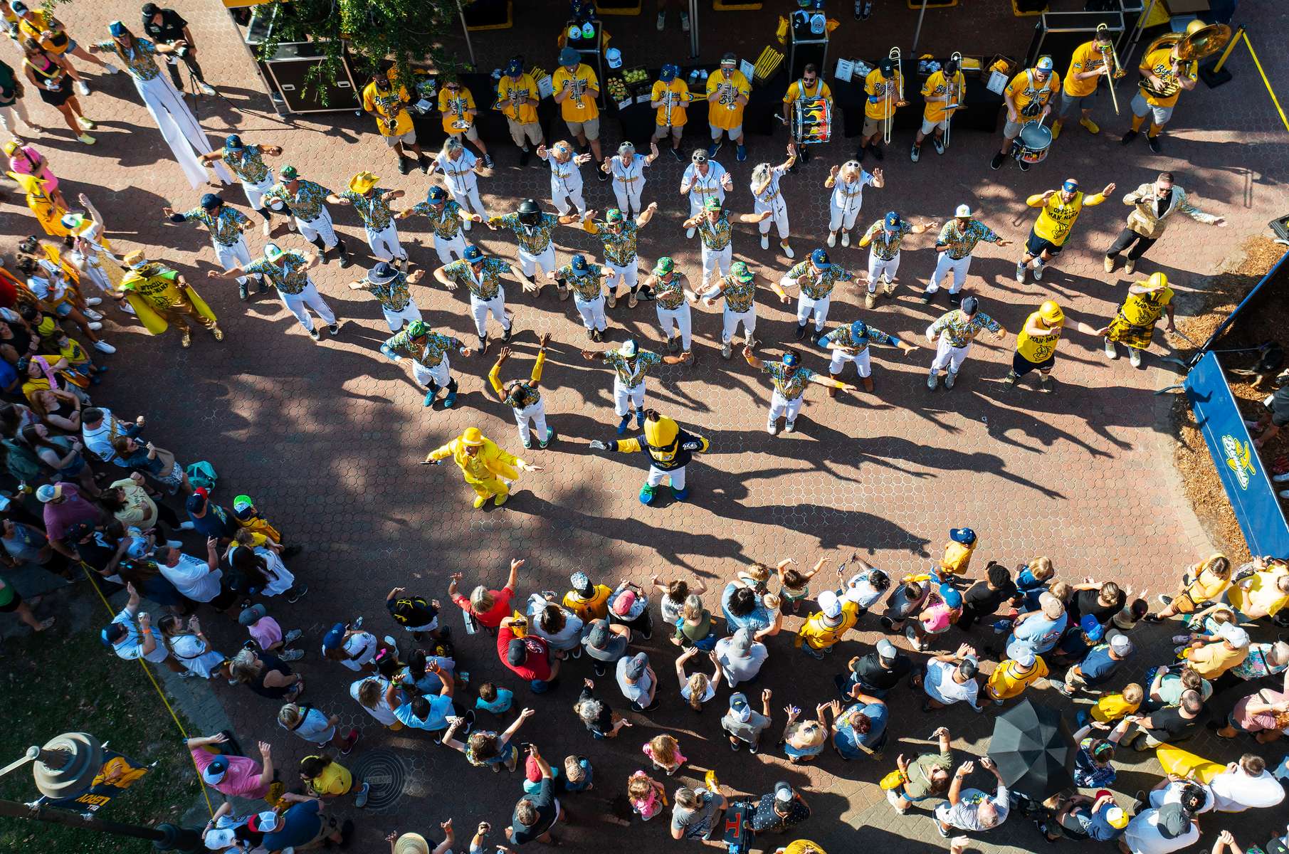 An aerial view of Savannah Bananas Team Owner Jesse Cole leading his team singing a rendition of {quote}Hey Baby{quote} during a pre game rally with the fans before their game against the Party Animals at Grayson Stadium on May 13, 2023 in Savannah, Georgia. 