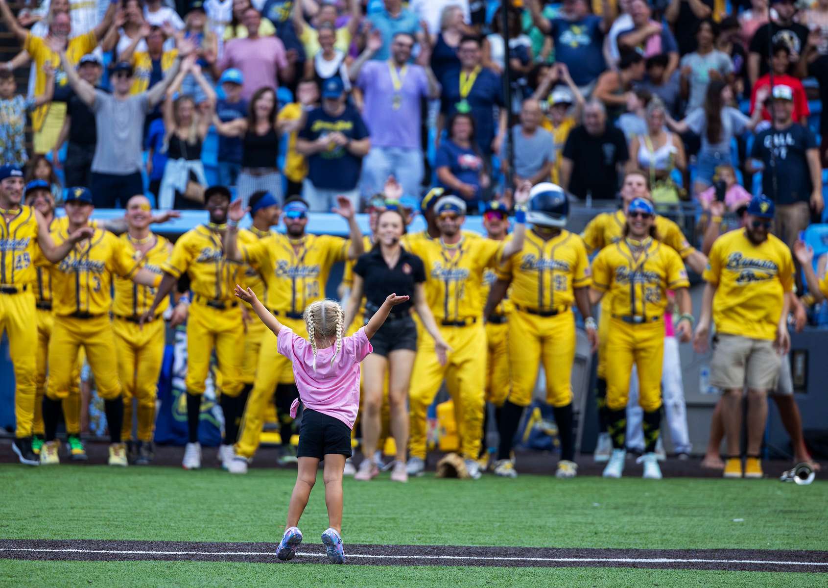 A young fan leads the Savannah Bananas and fans in a dance routine  before the game against the Party Animals at Richmond County Bank Ball Park on August 12, 2023 in New York City.  