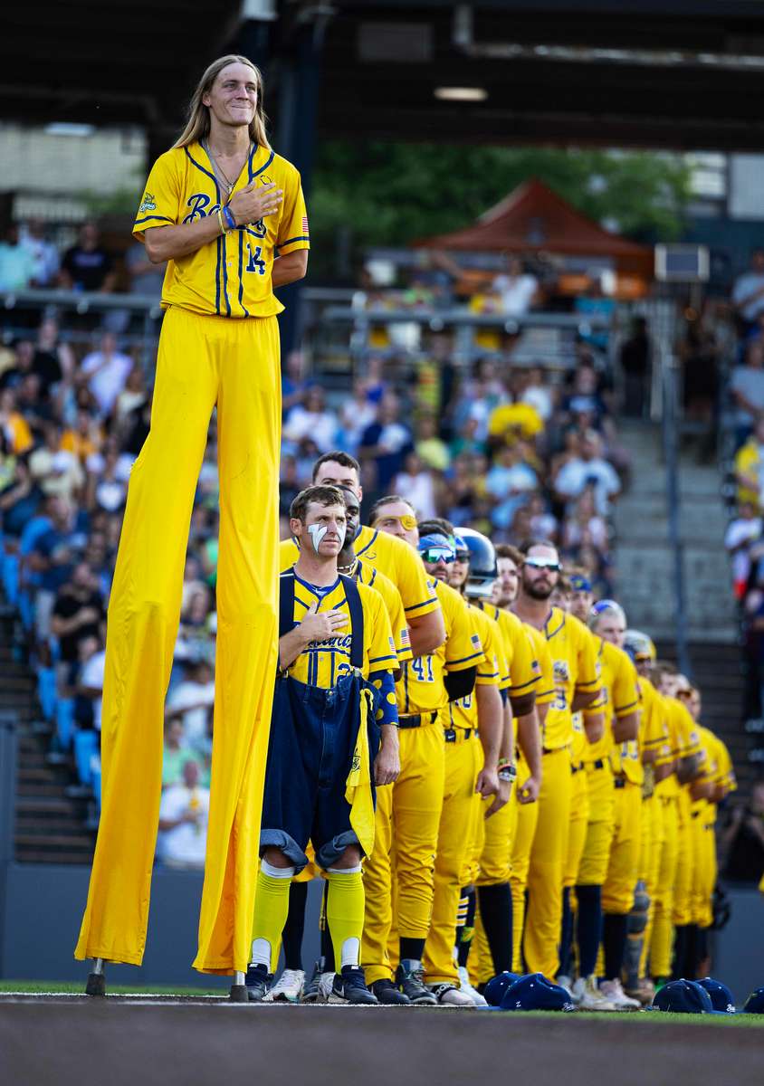 Dakota {quote}Stilts{quote} Albritton #14 of the Savannah Bananas stands with his team during the national anthem before their game against the Staten Island Ferryhawks at Richmond County Bank Ball Park on August 11, 2023 in New York City.  