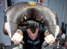 Thomas De Giuli swings a Bulgarian bag during a workout at the Strength Factory gym during a workout at the Strength Factory gym on July 18, 2022 in Baldwin, New York.  The workouts are led by De Giuli who owns the gym.  The athletes he trains use unconventional fitness training methods when they exercise.  