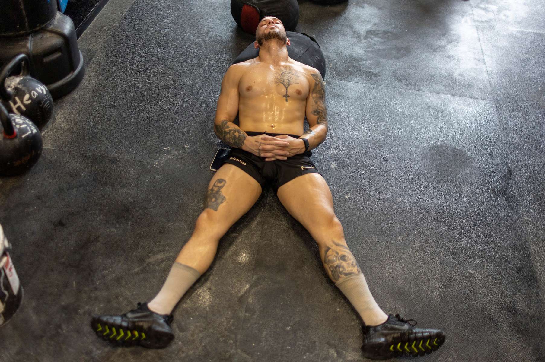 Thomas De Giuli, lies exhausted after a workout at the gym he owns called the Strength Factory on July 18, 2022 in Baldwin, New York.  The workouts are led by De Giuli and the athletes he trains use unconventional fitness training methods when they exercise.  