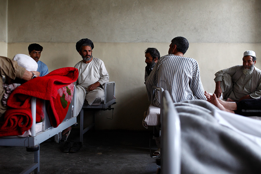 Patients and visitors sit around in a room at the drug dependency ward.