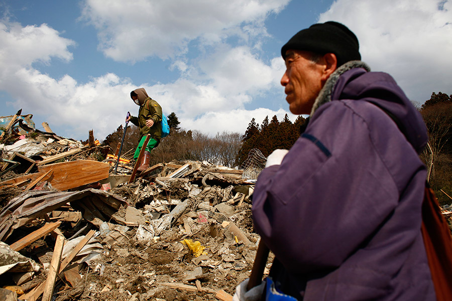 Family members try to locate their belongings where they believe their house once stood in Rikuzentakata, Iwate, Japan.