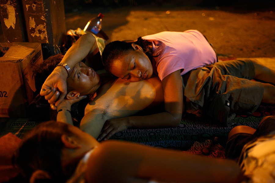 Veronica lies on top of Eric as the night falls at the underpass structure of the bus terminals.  