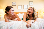 Vermont wedding at The Ponds at Bolton Valley Resort. Bride and bridesmaid laughing while getting ready.