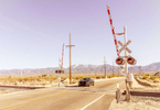 Photograph of 2016 Ford Mustang driving on desert road near rail road crossing signs  photographed by Red Cup Studio