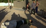 Locals gather around the body of a slain Syrian fighter who was shot to death by residents the day the city of Kirkuk fell.