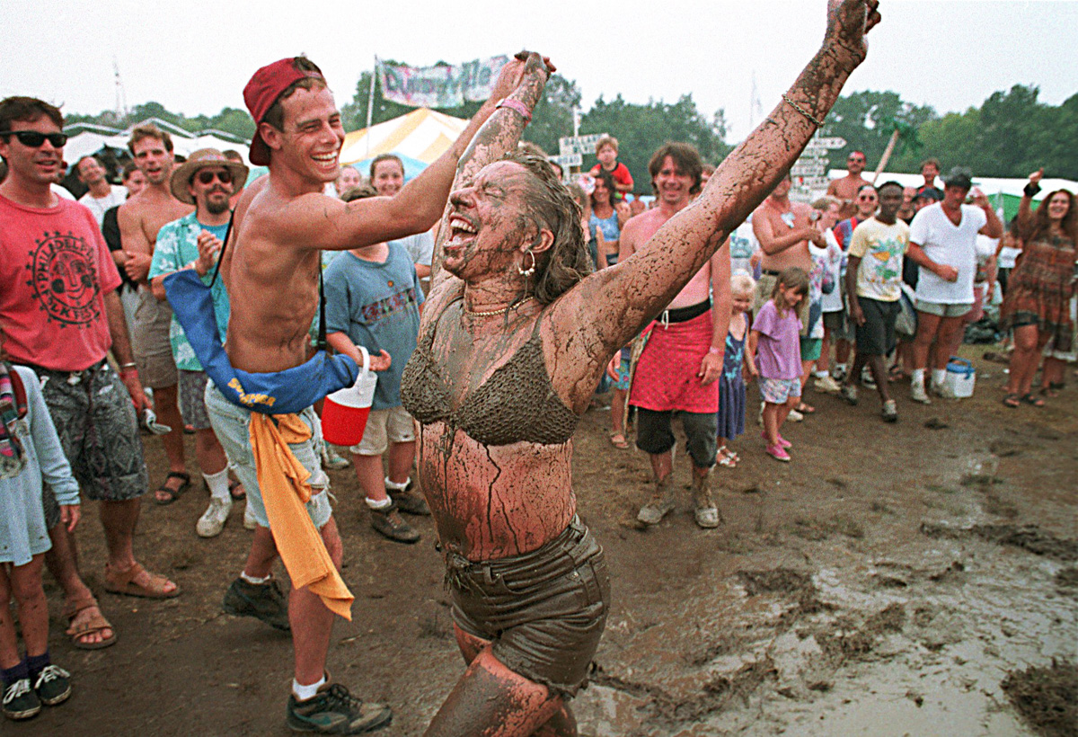 Campers at the Philadelphia Folk Festival celebrate a downpour by sliding through the mud.